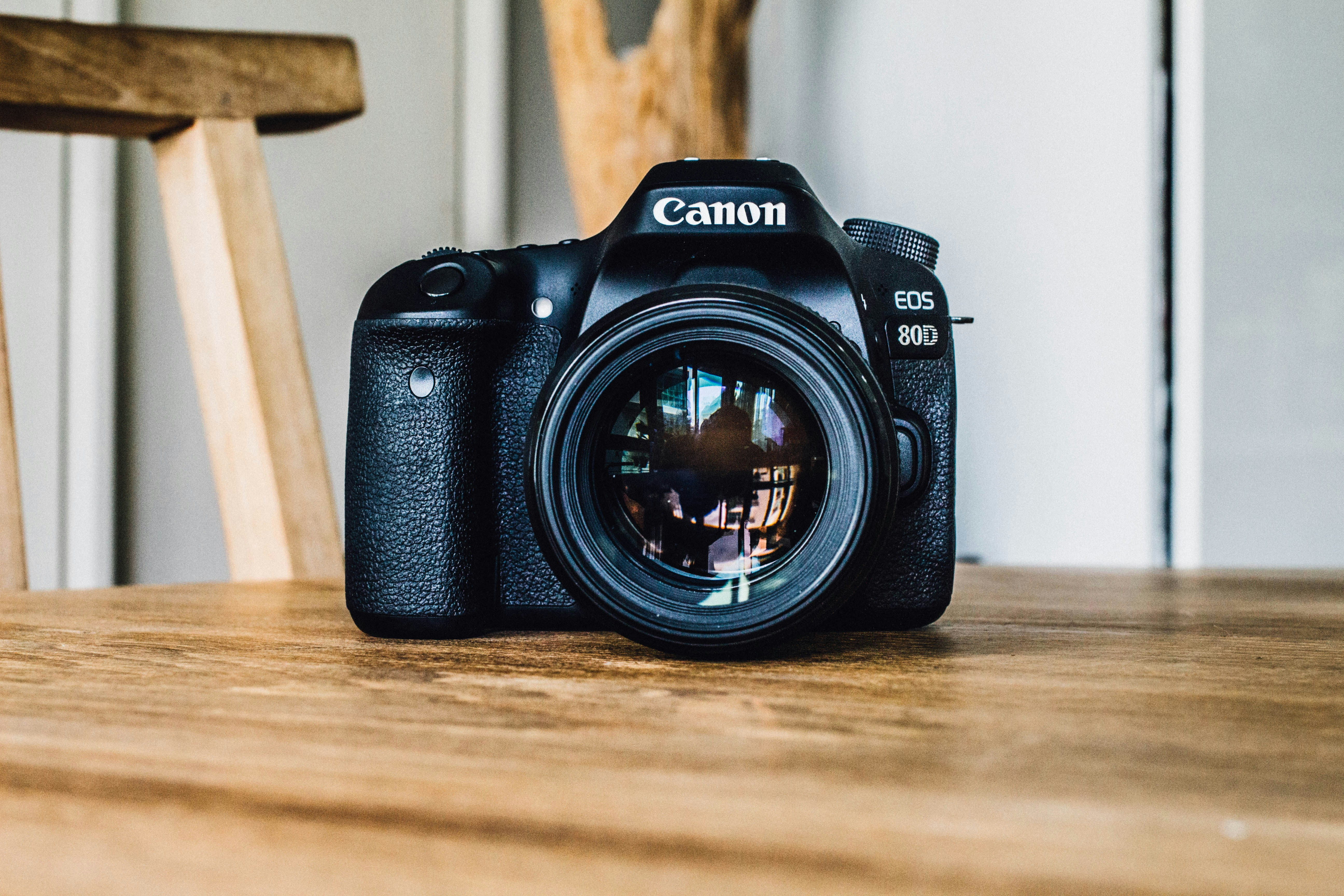 Stock photography of a camera EOS 80D by canon on a wooden table